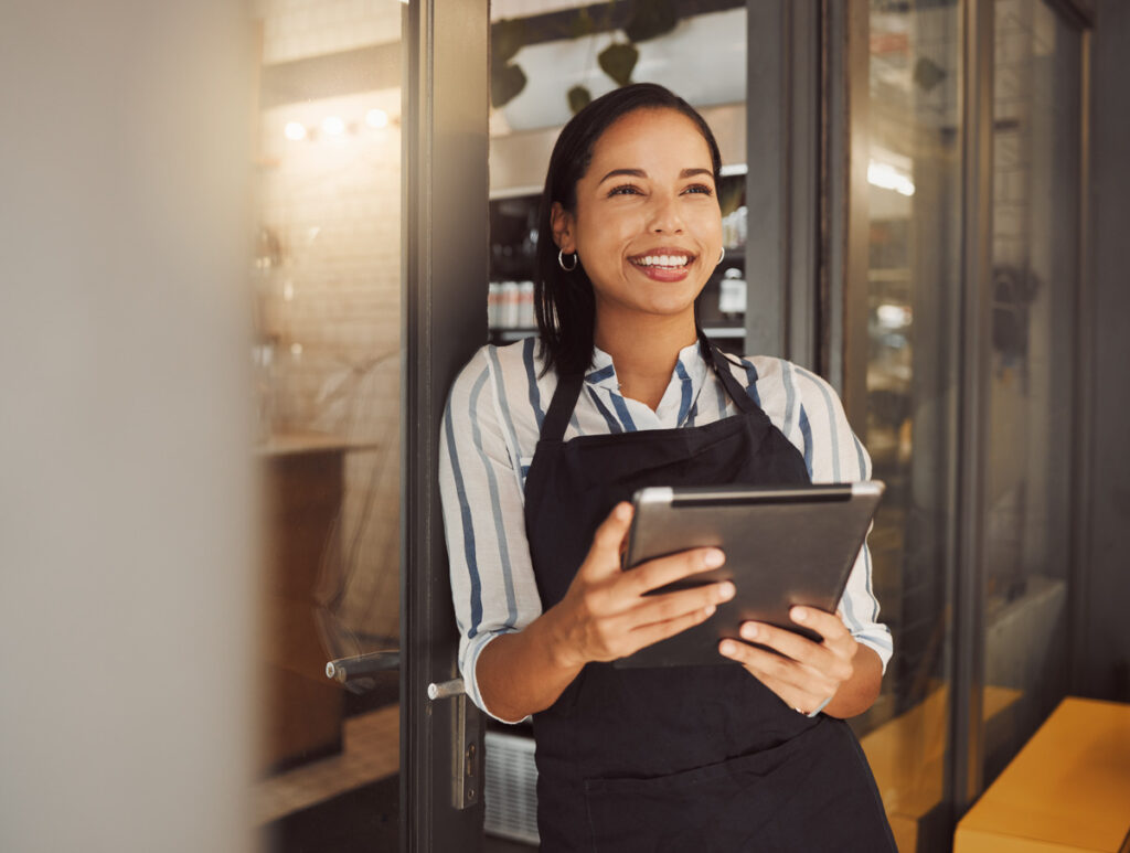 Happy Businesswoman Using A Digital Tablet In Her Shop. Business